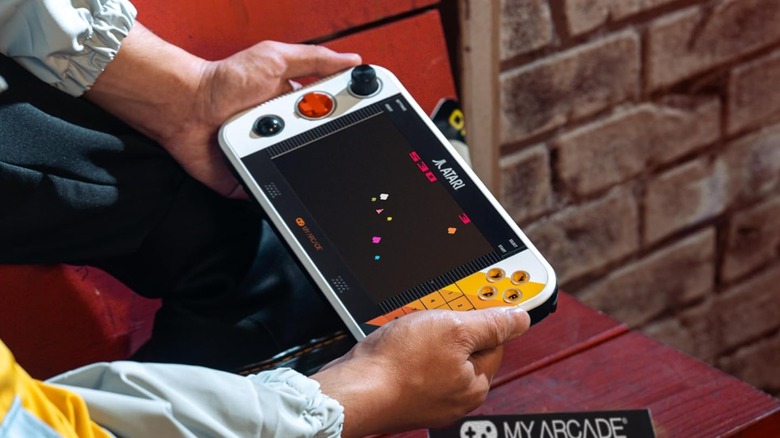 A close-up view of the My Arcade Atari Gamestation Go being held in two hands.