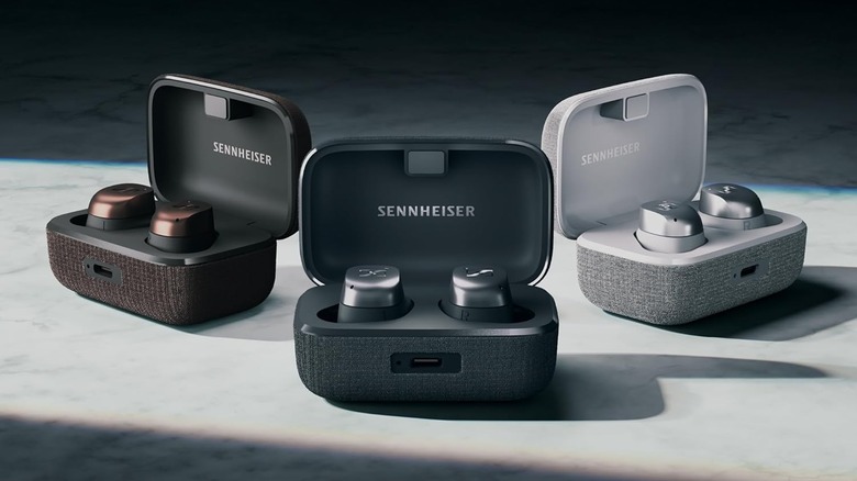 Three color versions of the Sennheiser Momentum True Wireless 4 earbuds and their charging cases.