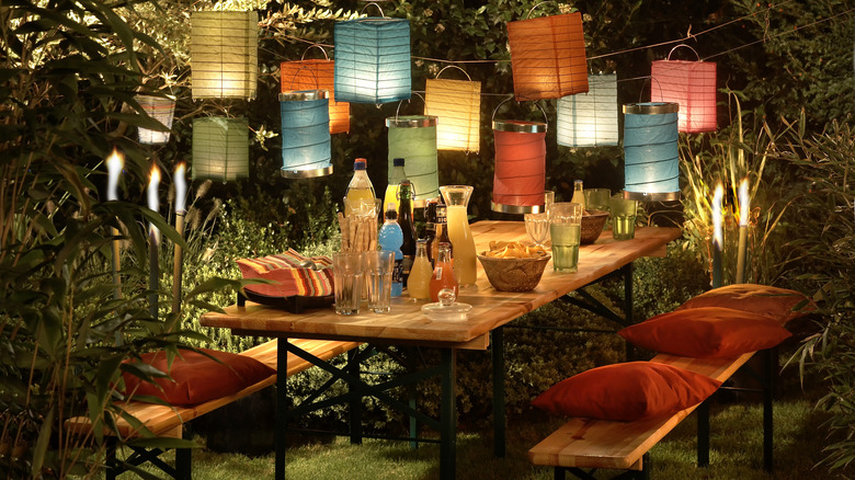 A beautifully lit backyard dining area prepared for an evening party or gathering.