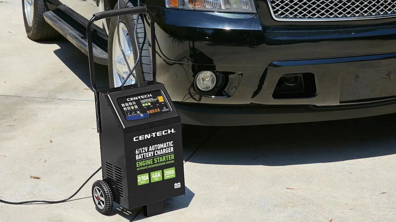 Cen-Tech 200 Amp wheeled automatic battery charger in a driveway setting next to a car.