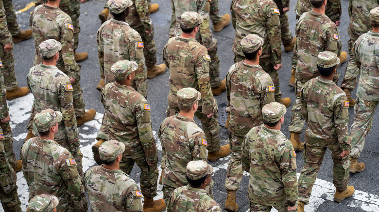 US Army soldiers walking in formation wearing standard duty uniforms.