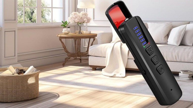 A Dronewing hidden spy camera detector on a table in a residential living room setting.
