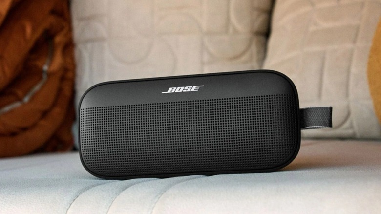 A Bose SoundLink Flex SE Gen 2 Bluetooth speaker resting on a soft cushion, showcasing its portable and durable design. [4]