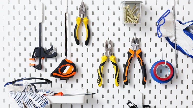 Various tools neatly organized on a pegboard wall.