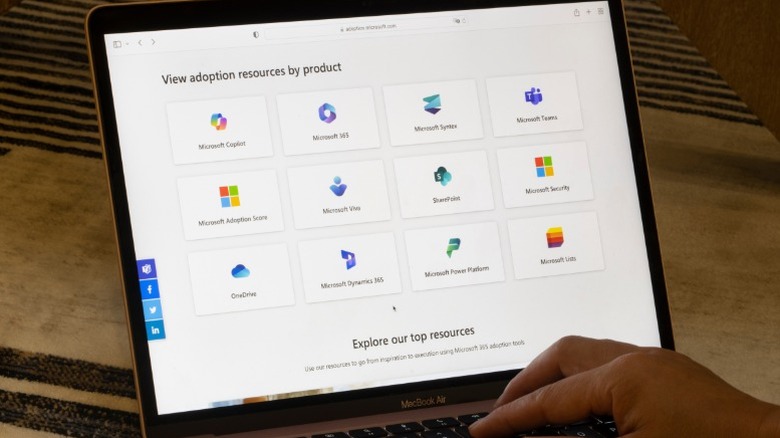 A laptop screen displaying various Microsoft cloud service icons and applications.