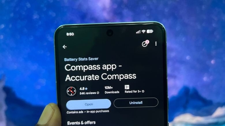 A hand holding a smartphone displaying an Accurate Compass application.