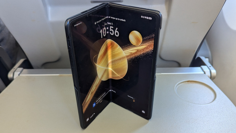 Honor Magic V3 being used for productivity tasks on a plane tray table.