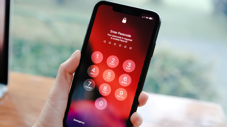 Close-up of an iPhone screen with a numeric keypad for passcode entry.