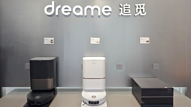 Multiple Dreame robot vacuums displayed on a showroom floor showing their slim circular designs.