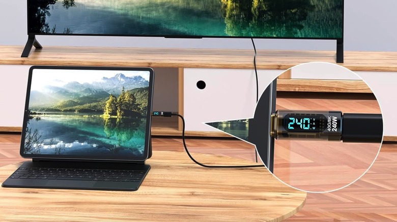 A USB-C power meter connected to a tablet and a display, measuring active power delivery.