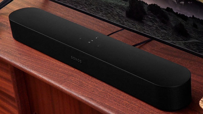 A black Sonos Beam Gen 2 soundbar positioned neatly on a light wood media console.