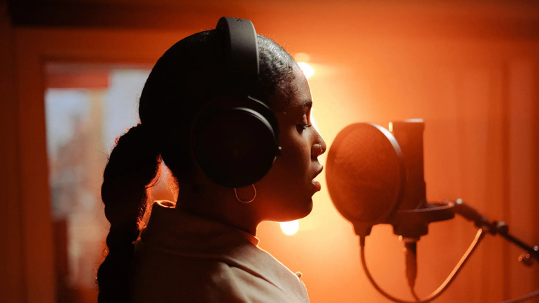 A person recording in a studio while wearing Beyerdynamic DT 700 Pro X closed-back headphones.