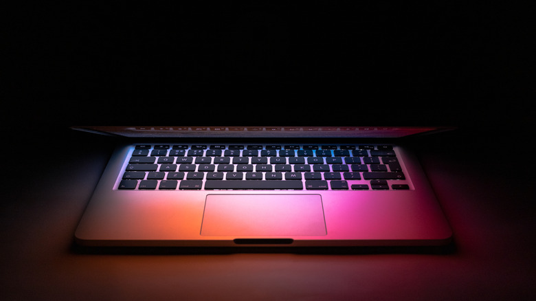 A laptop open in a dark room, highlighting the context for low-light browsing.