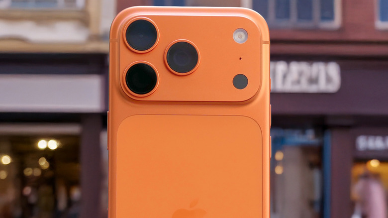 Close-up of a modern smartphone's back panel and camera housing in a vibrant orange finish.