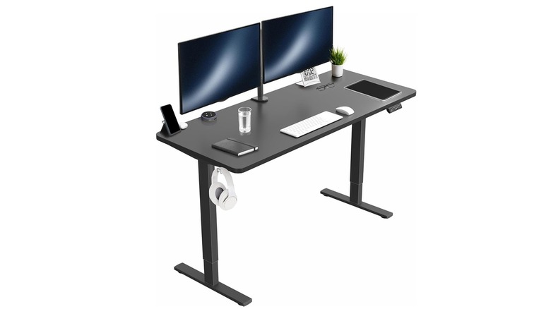 A Vivo electric standing desk configured with dual monitors, a keyboard, and office accessories.