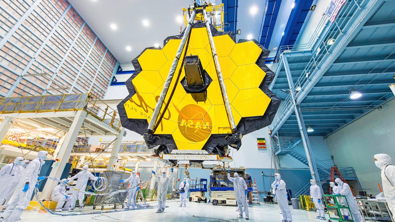 Engineers in a cleanroom assembling the gold-plated mirrors of the James Webb Space Telescope.