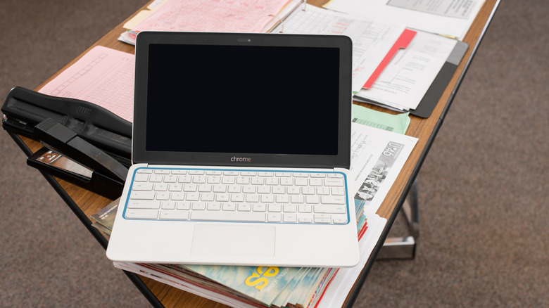 An HP Education edition Chromebook sits on a desk in a classroom.