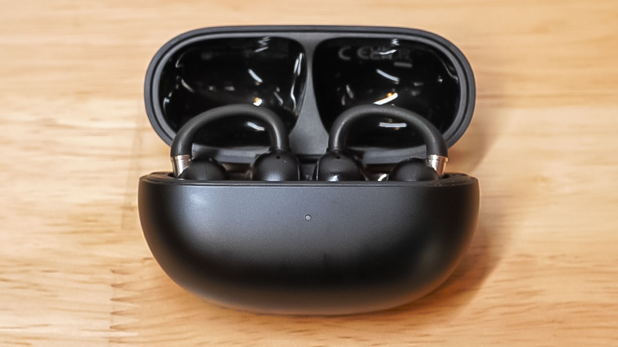 Open charging case showing the two EarFun Clip 2 earbuds docked inside.