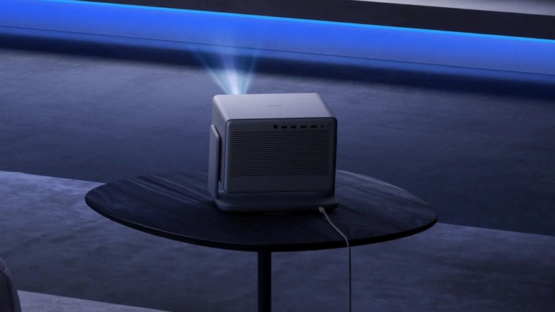 A smart projector placed on a coffee table projecting a bright image in an indoor setting.
