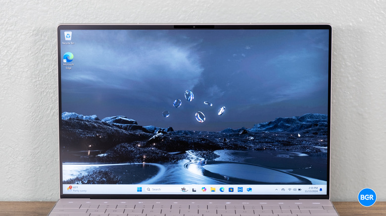 The Dell XPS 13 9350 with its screen turned on, showing high contrast and thin InfinityEdge bezels.