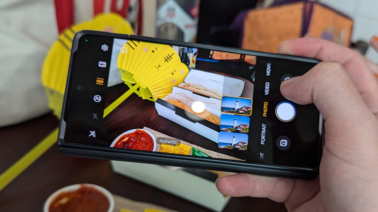 A person holding the Honor Magic V3 to take a photograph.
