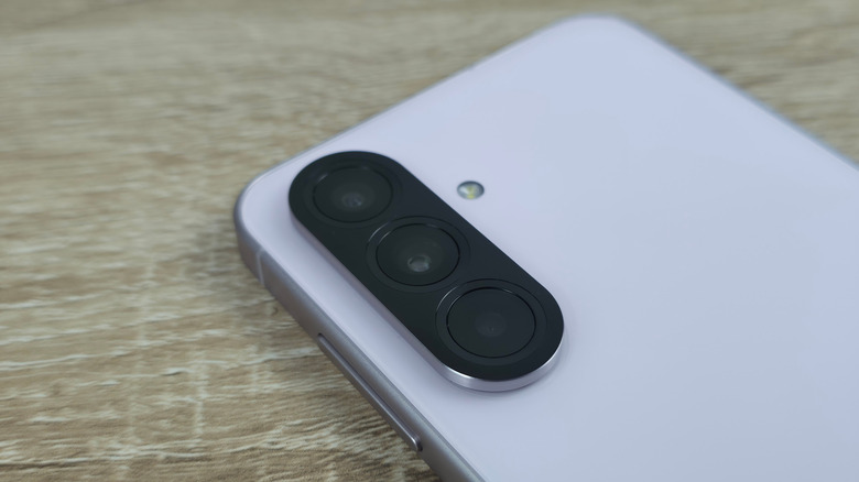 Macro detail of the triple-lens camera array on the back of a Samsung Galaxy A56.