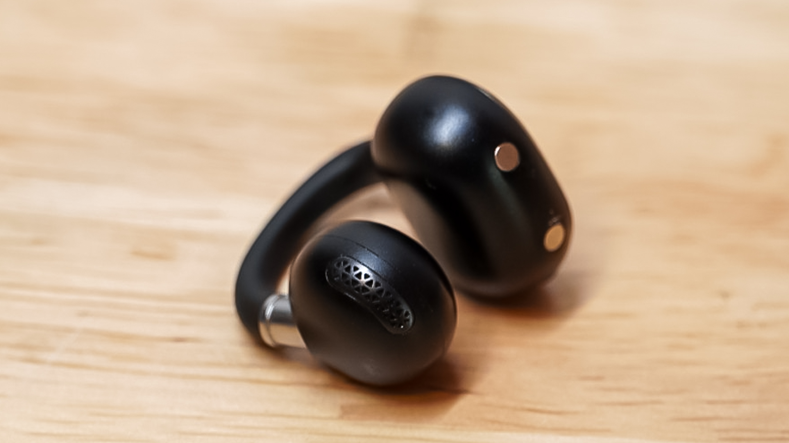 Macro shot of a single EarFun Clip 2 earbud focusing on the inner speaker grille.