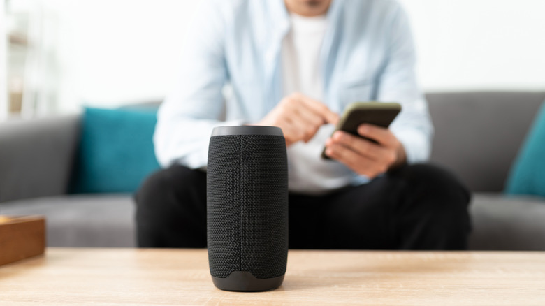 Close-up of a person connecting their smartphone to a bluetooth speaker.