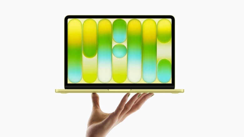 A hand holding the MacBook Neo to show its thin and light aluminum unibody.