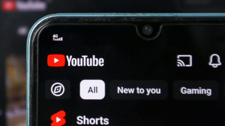A smartphone screen displaying the YouTube app with a clear focus on the Cast icon in the top right.