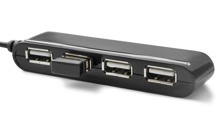 A white four-port USB hub designed for computer or console expansion.
