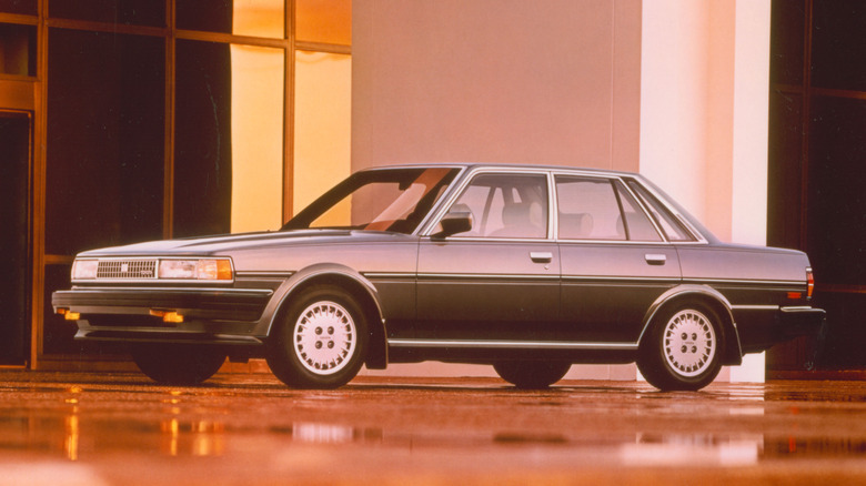 A silver Toyota Cressida luxury sedan parked in front of an office building