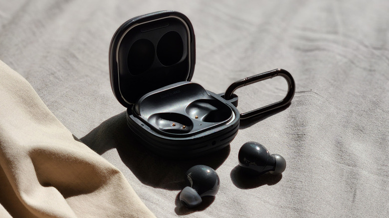Top-down view of an open Samsung Galaxy Buds charging case with the earbuds removed and placed in front.