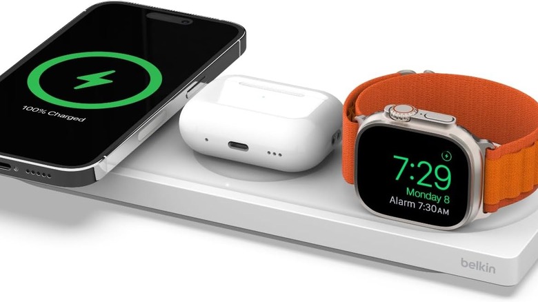 A Belkin wall charger simultaneously powering three mobile devices via USB cables.