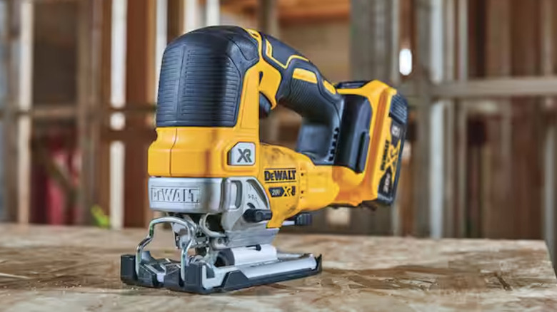A DeWalt cordless jigsaw being used to precisely cut through a piece of lumber on a job site.