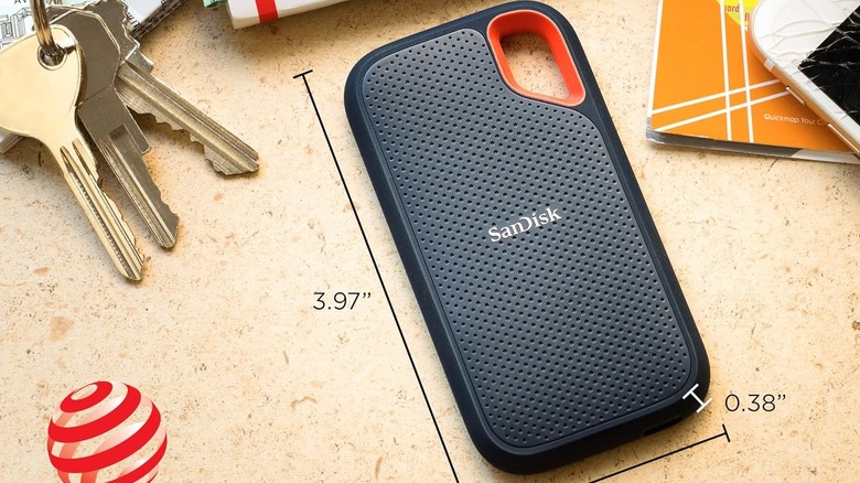 A rugged SanDisk Extreme external SSD placed on a wooden surface.