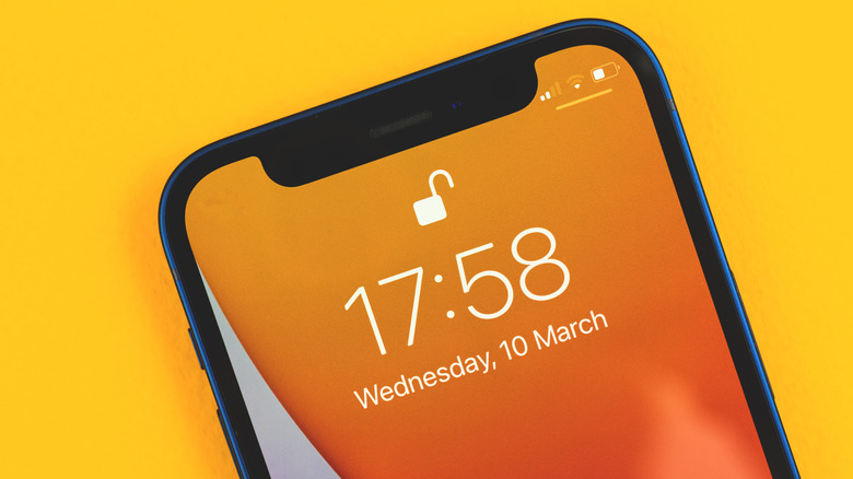 A person holding an iPhone that has been successfully unlocked and is at the home screen.