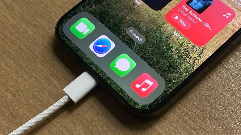 A close-up of a white USB-C cable plugged into the bottom port of a modern smartphone.