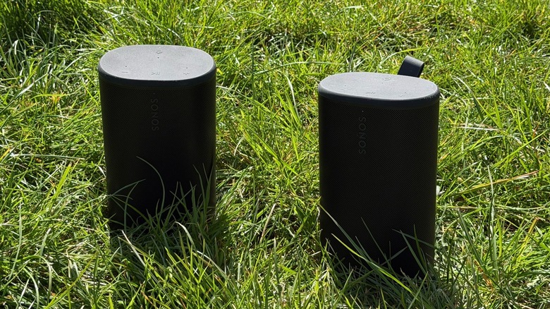 Two Sonos Play speakers sitting on green grass to illustrate their rugged, IP67-rated construction.