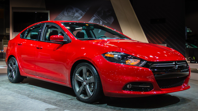 A red 2013 Dodge Dart on display at an auto show.