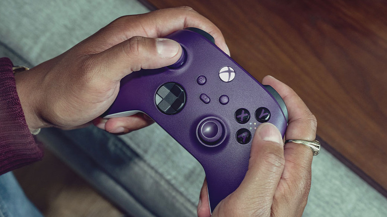 Hands holding a vibrant purple Xbox wireless controller ready for pairing.