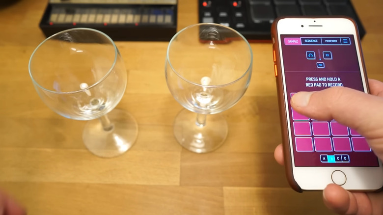 A smartphone being used for audio creation on a desk next to personal items.