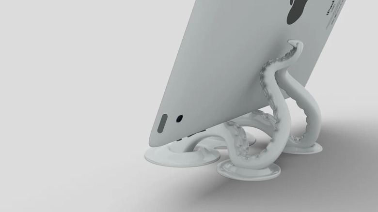 An iPad tablet resting on a creatively designed 3D printed stand shaped like octopus tentacles.