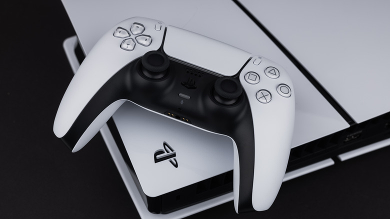 A PS5 console with its DualSense controller on a flat surface.