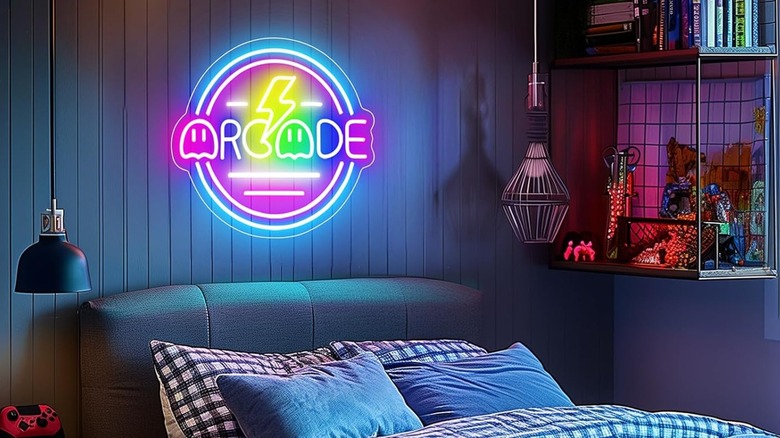 A vibrant blue and pink 'Gamer Arcade' neon sign mounted on a wall.
