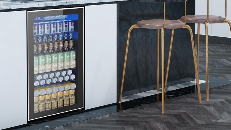 An Electactic beverage refrigerator built into a sleek counter next to gold seating.