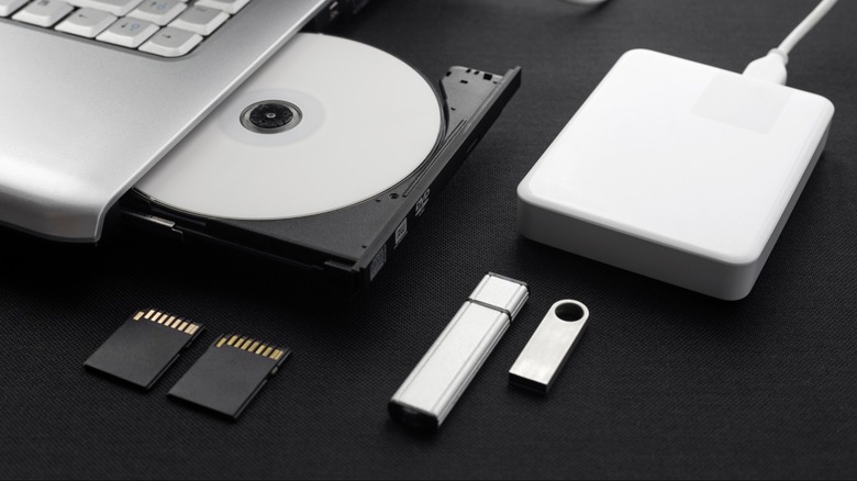 An array of storage media including an optical drive, an external hard drive, and USB flash drives.