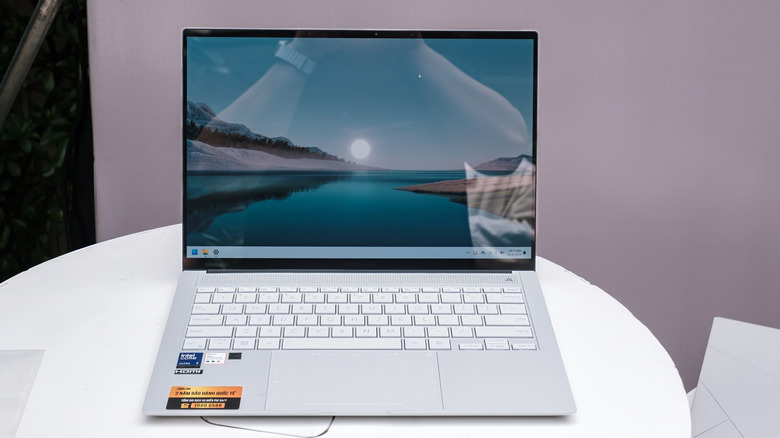 The ASUS Zenbook S 14 featuring a Ceraluminum finish resting on a modern round table.
