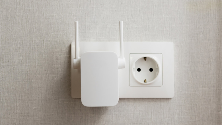 A Wi-Fi extender plugged directly into a standard electrical wall outlet.