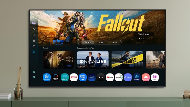 A Samsung S90F QD-OLED TV mounted flush against a wall in a minimalist room.